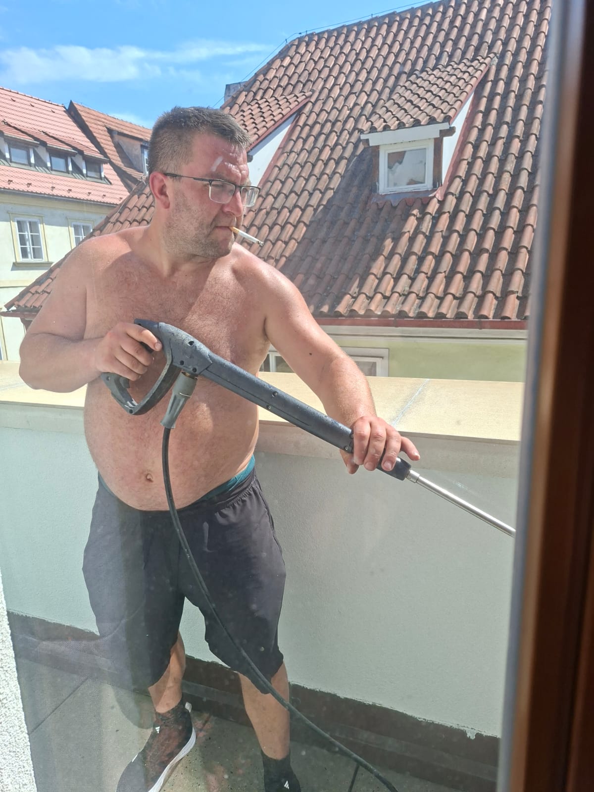 Pracovník myje střechu vysokotlakým čističem